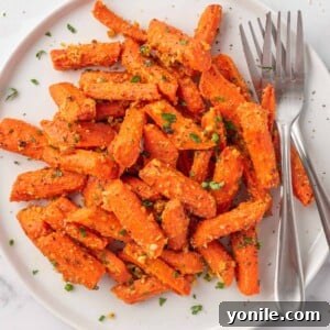 Roasted carrots with parmesan cheese on a plate with two forks.