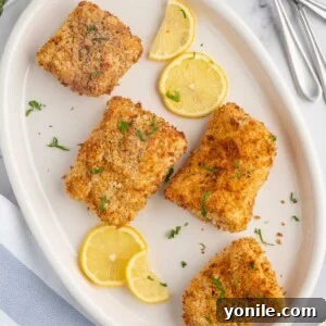 A plate of crispy air fryer cod with lemon slices.