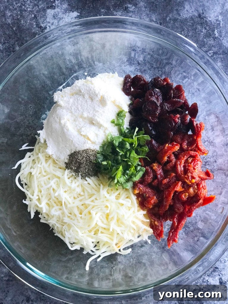 Ingredients for Cheesy Sundried Tomato Stuffed Chicken, showcasing the creamy filling and aromatic herbs.