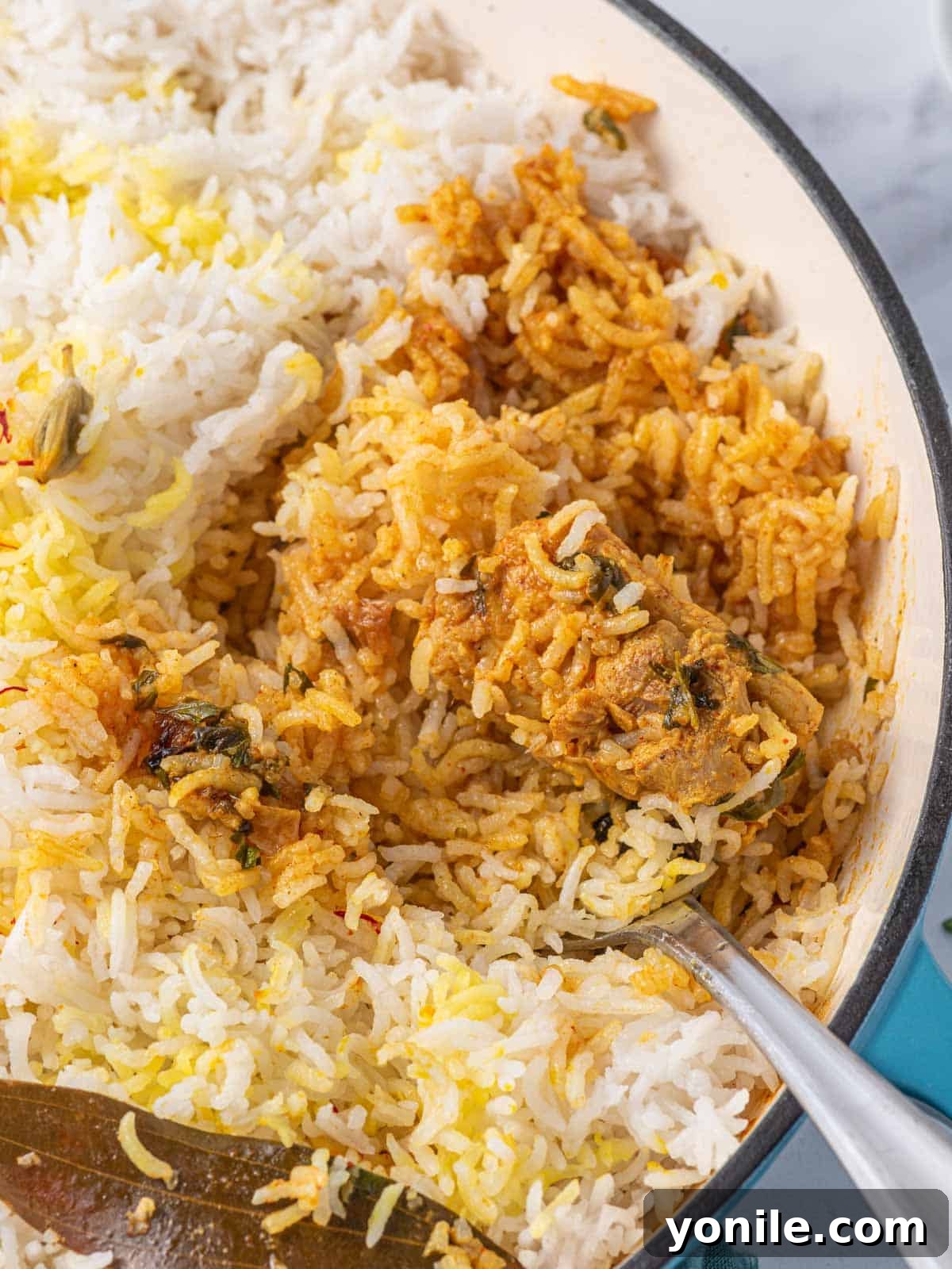 Quick Chicken Biryani 7 A close-up shot of a forkful of tender chicken and fluffy, aromatic biryani rice, showcasing the texture and rich colors.