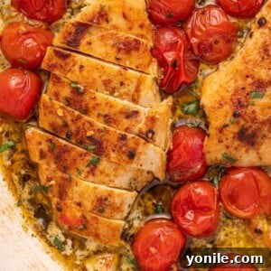 Chicken breast with creamy pesto cut into slices in a skillet.