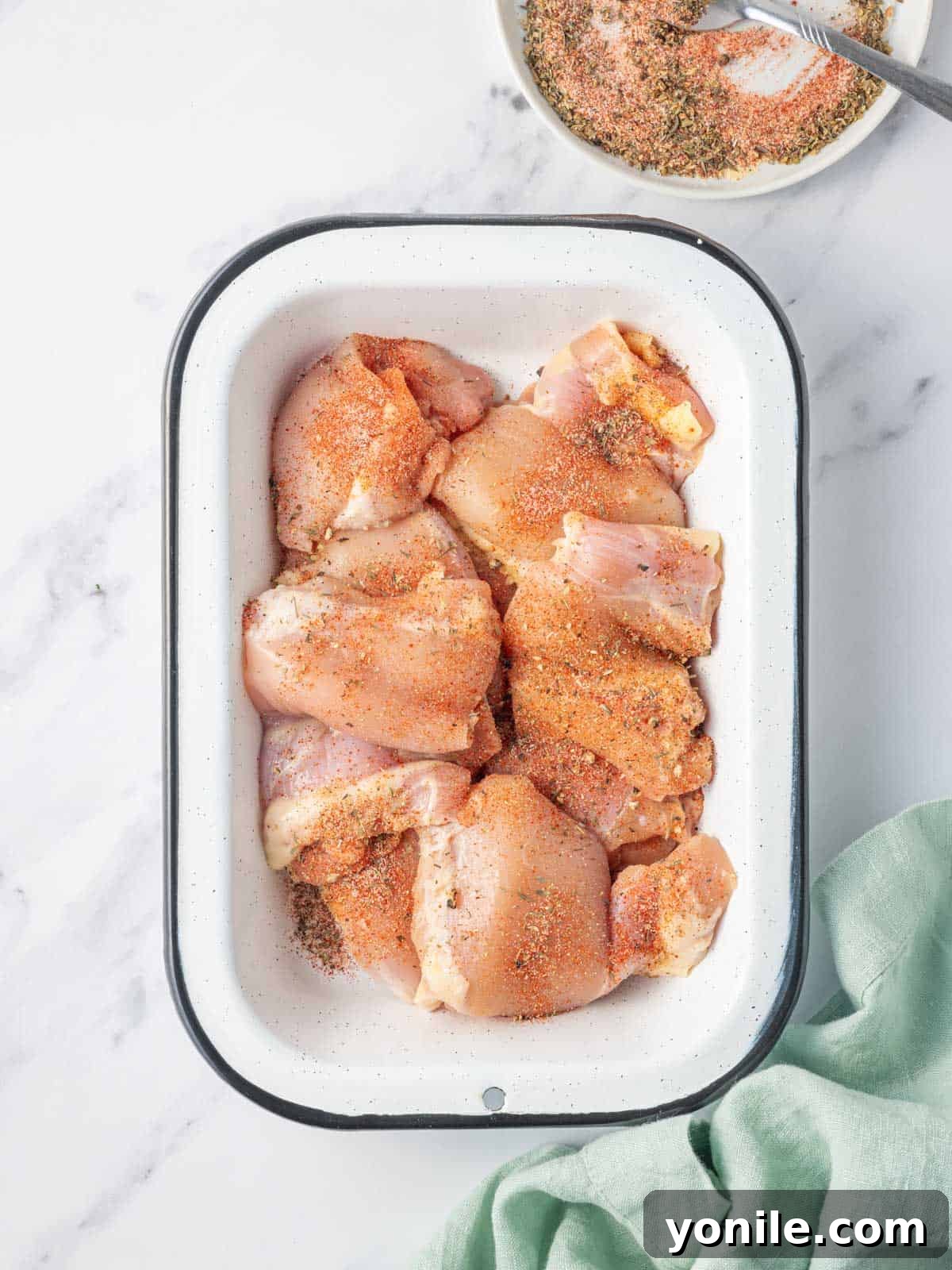 Air Fryer BBQ Chicken Perfection 4 Seasoning raw chicken thighs in a dish.