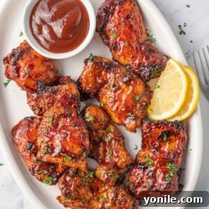 Air Fryer BBQ Chicken Perfection 9 Air fryer bbq chicken on a plate with extra barbecue sauce.