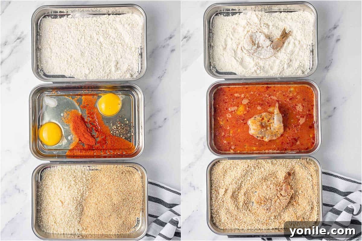 An overhead view of a breading station set up with three bowls: one with flour, one with whisked eggs and spices, and one with mixed panko and regular breadcrumbs, ready for coating butterfly shrimp.