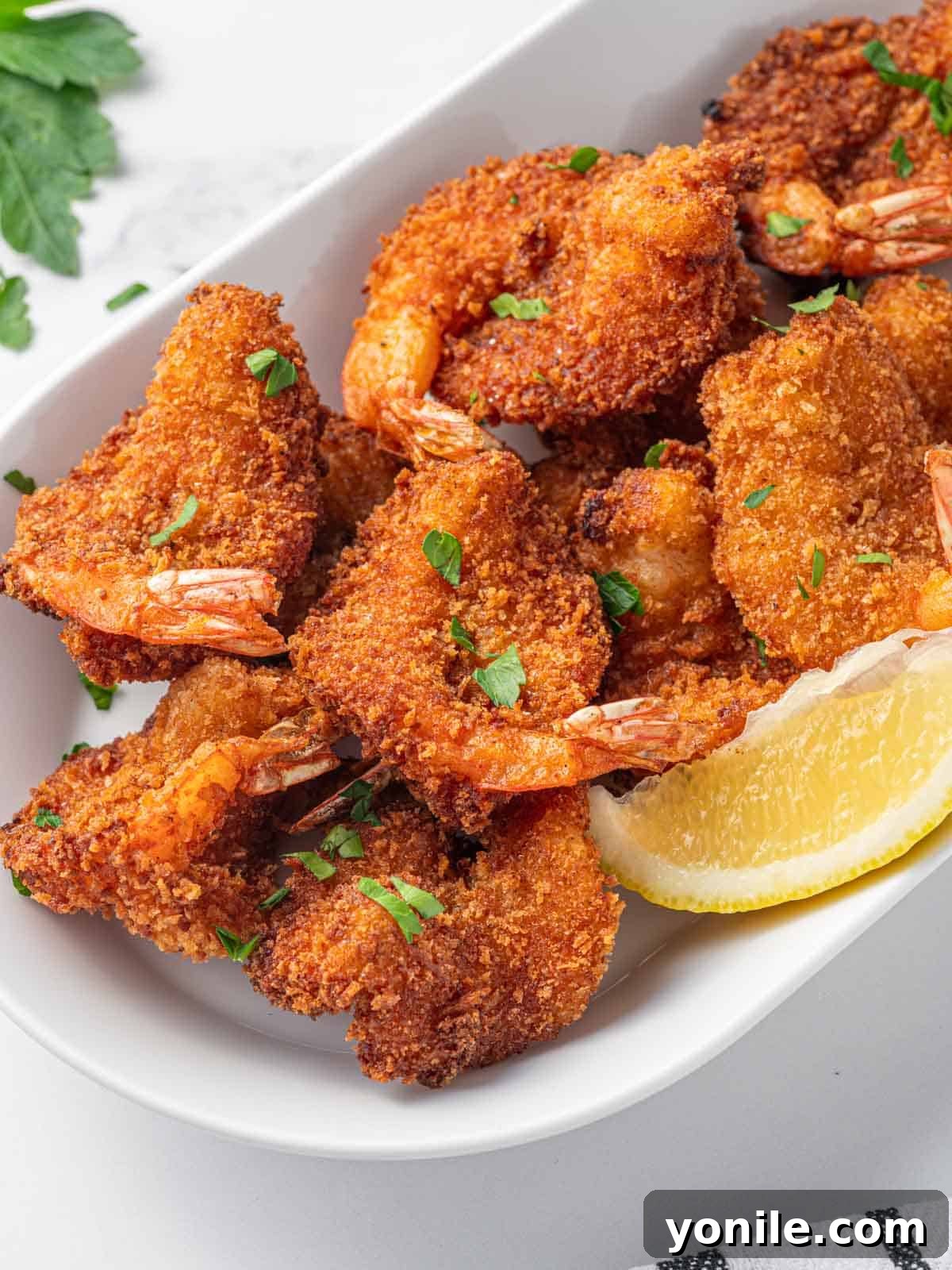 A close-up shot of several perfectly breaded butterfly shrimp, showcasing their golden, crispy coating and tender texture.