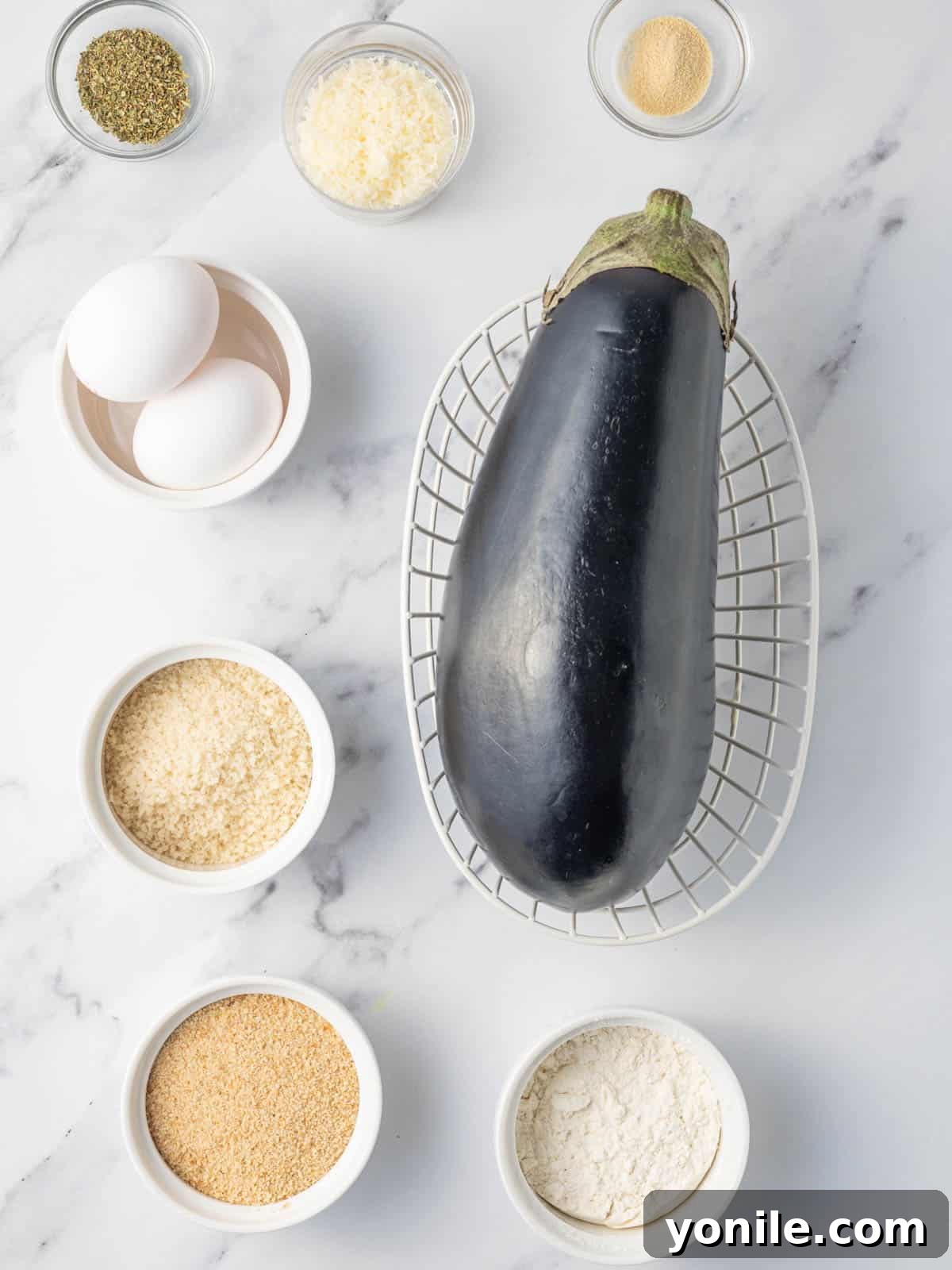 Golden Crispy Air-Fried Eggplant 3 A selection of fresh ingredients, including eggplant, flour, eggs, and breadcrumbs, ready for crispy air fryer eggplant preparation.