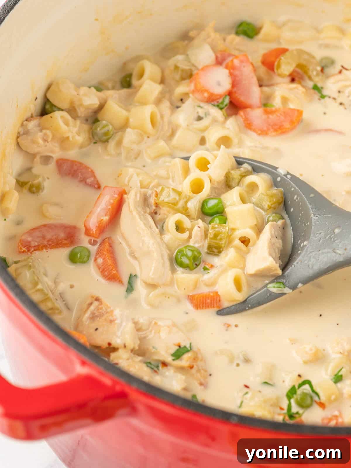 Velvety Chicken Garden Soup 6 A large pot of creamy chicken vegetable soup with a ladle, ready to be served.