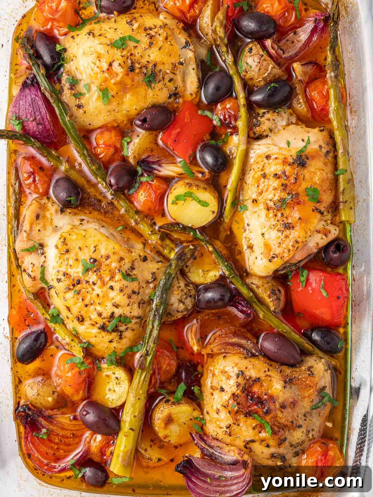 A close-up shot of a single serving of Mediterranean baked chicken, featuring juicy chicken and tender roasted vegetables, garnished with olives and fresh herbs, ready to be enjoyed.