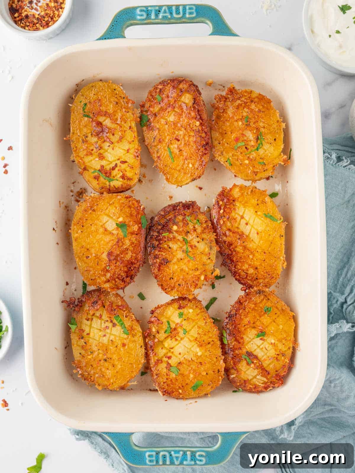 Garlic Parmesan roasted potatoes freshly baked and ready to serve in a rustic baking dish.