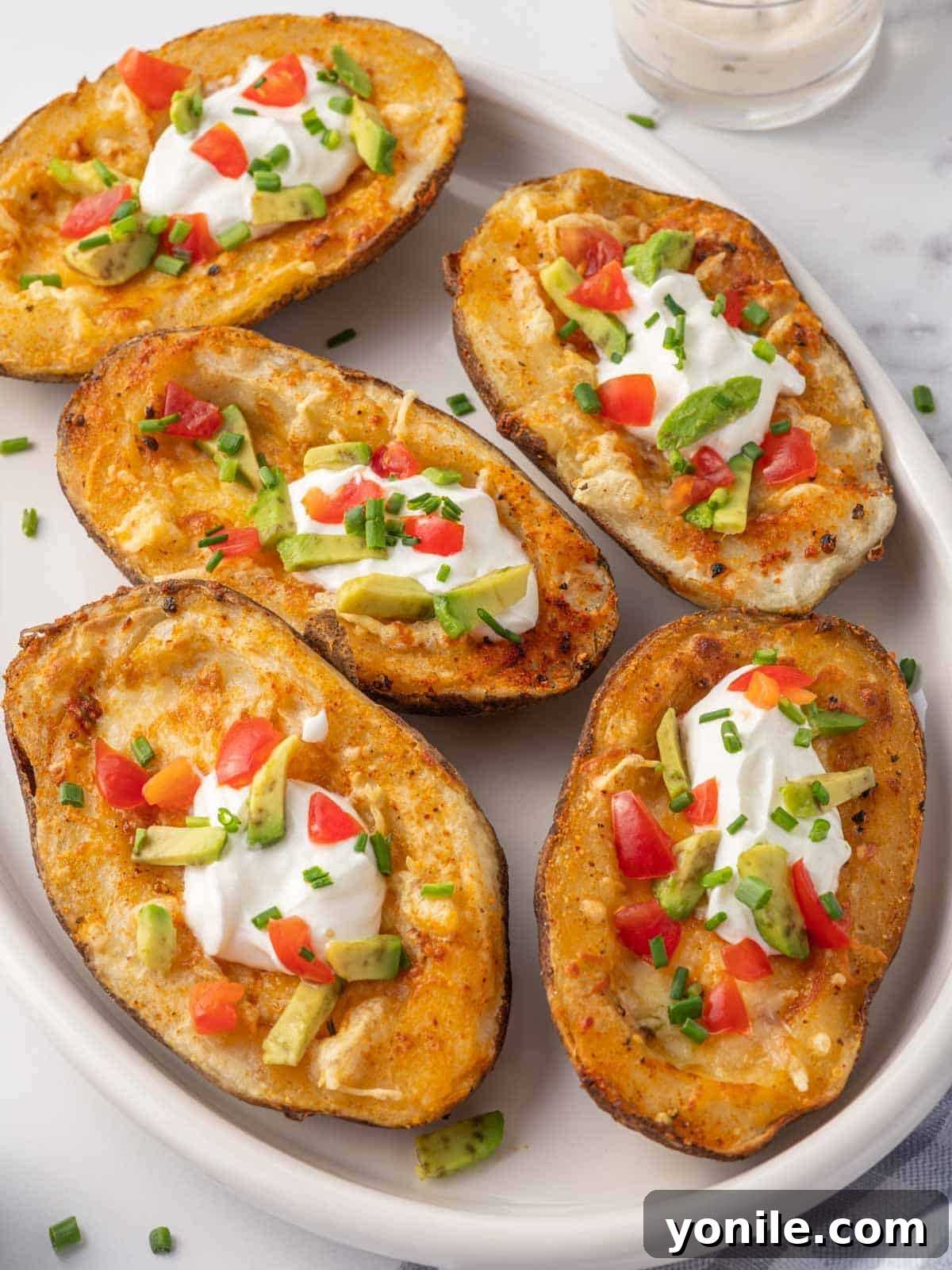 Crispy potato skins topped with cheese, sour cream, avocado and tomato.