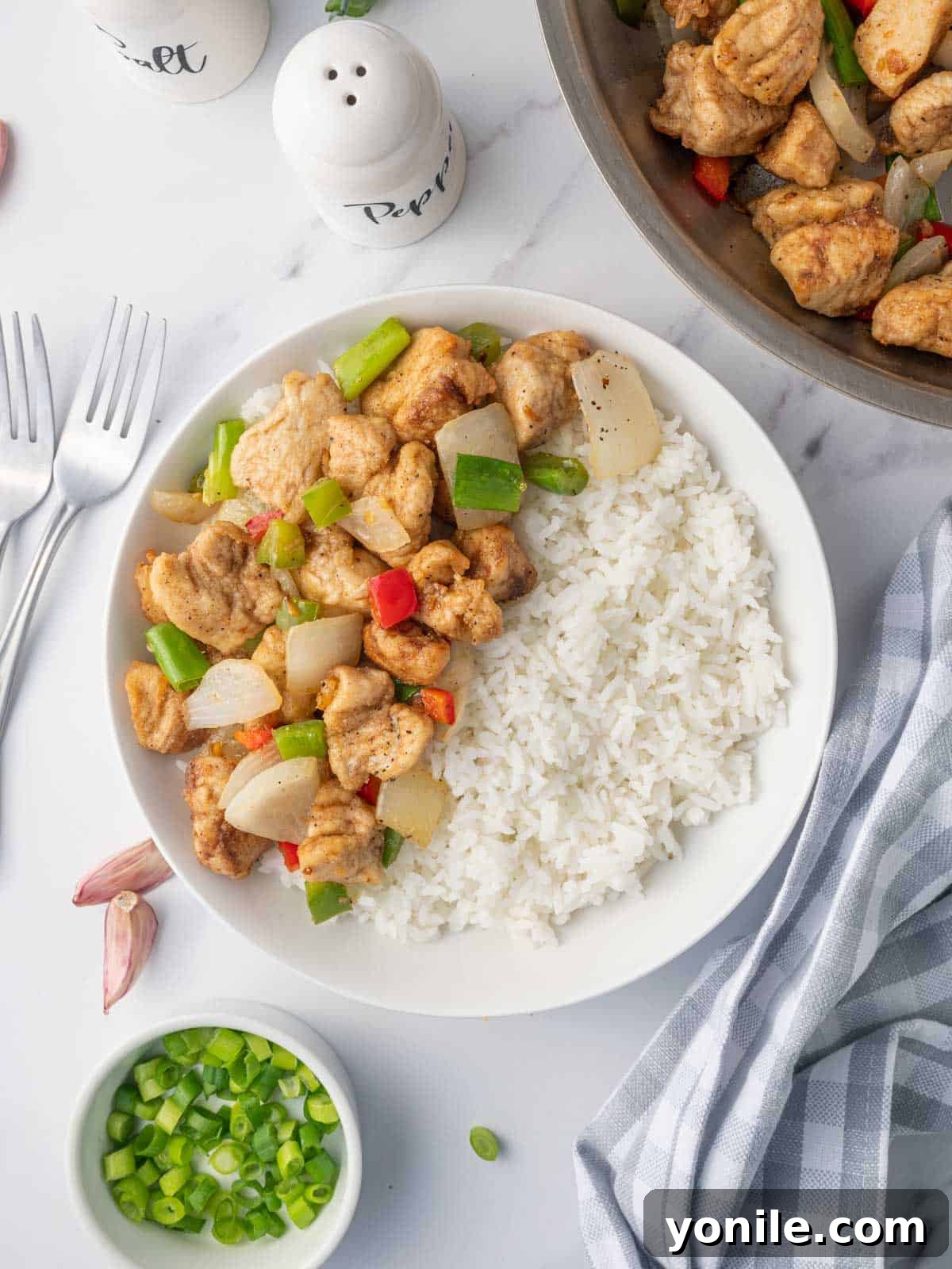 Golden Salt and Pepper Chicken 2 Crispy salt and pepper chicken with rice on a plate.