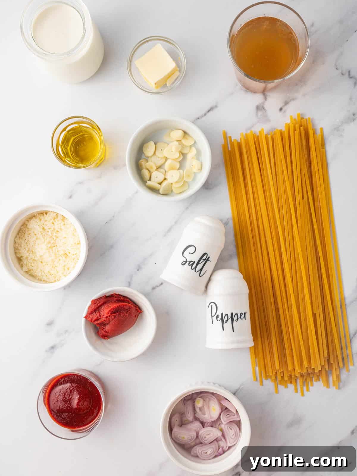 Velvet Gochujang Pasta 3 A selection of fresh ingredients including pasta, gochujang, garlic, and cream, laid out for making the pasta dish.