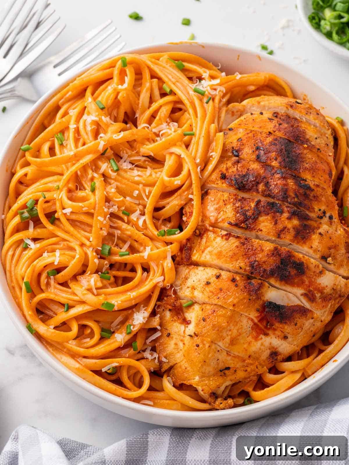 Velvet Gochujang Pasta 6 A plate of creamy Gochujang pasta served with a side of grilled chicken, showcasing a complete and appealing meal.