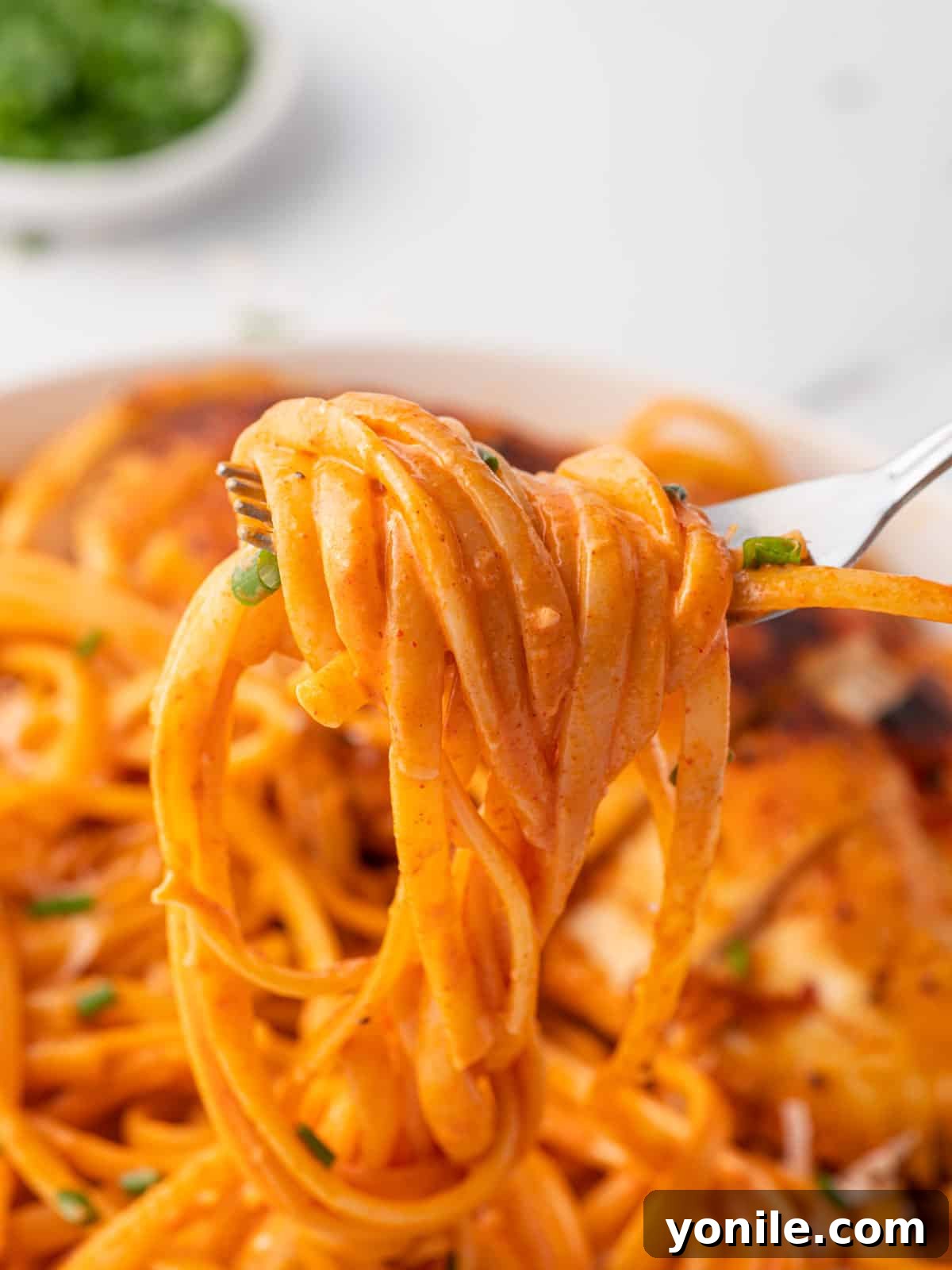 Velvet Gochujang Pasta 7 A fork twirled with linguine coated in creamy gochujang sauce, showing its inviting texture.