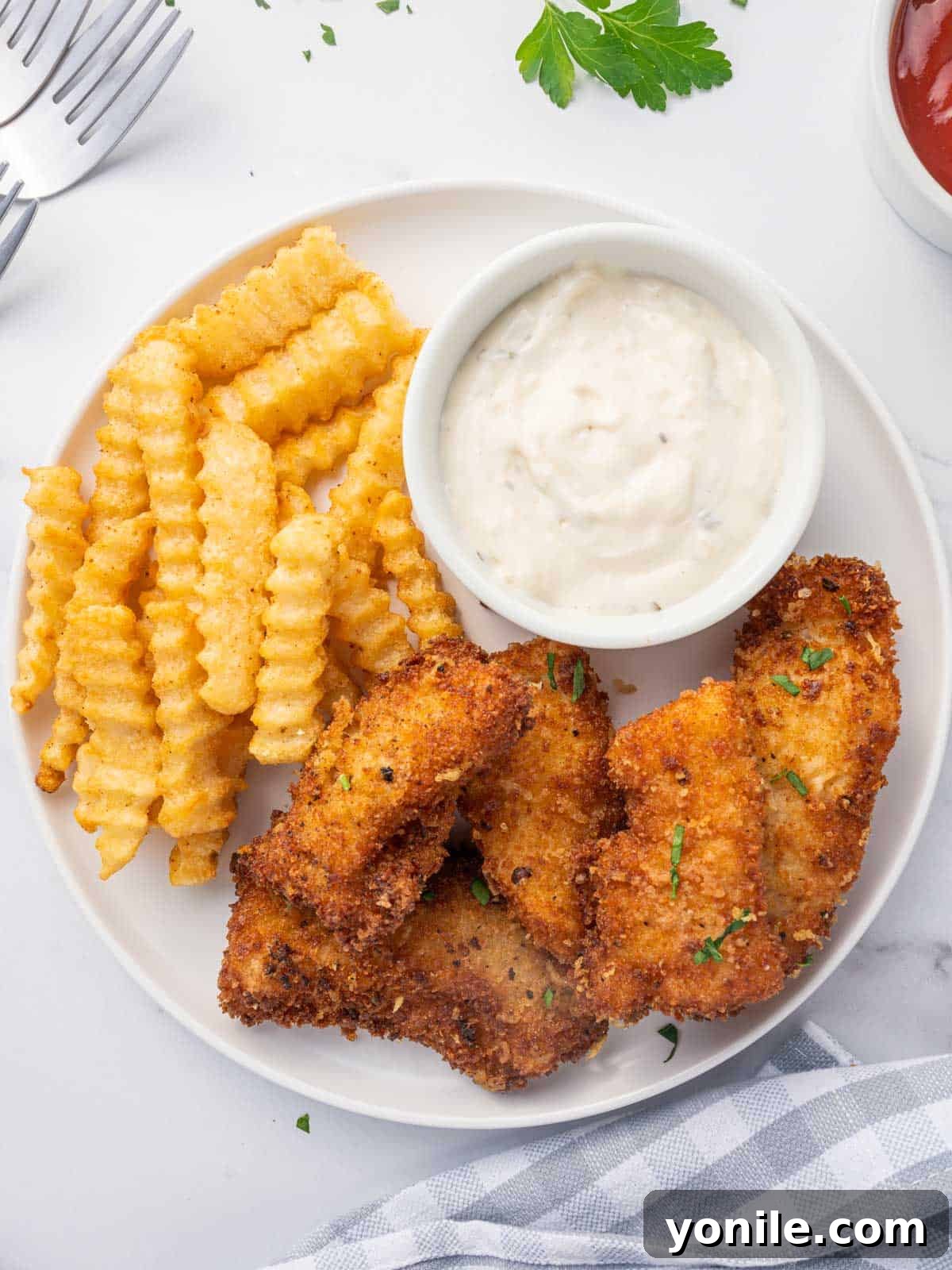 Crispy Gluten Free Fish and Chips 6 Gluten free fish with a side of fries and dip, ready to be served.