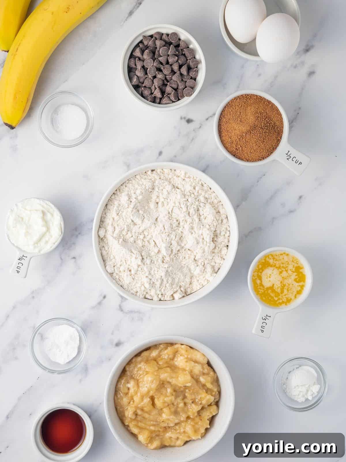 All the fresh ingredients meticulously laid out for baking gluten-free banana muffins, including ripe bananas, chocolate chips, and flour.