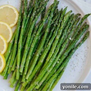A plate of asparagus with lemon slices.
