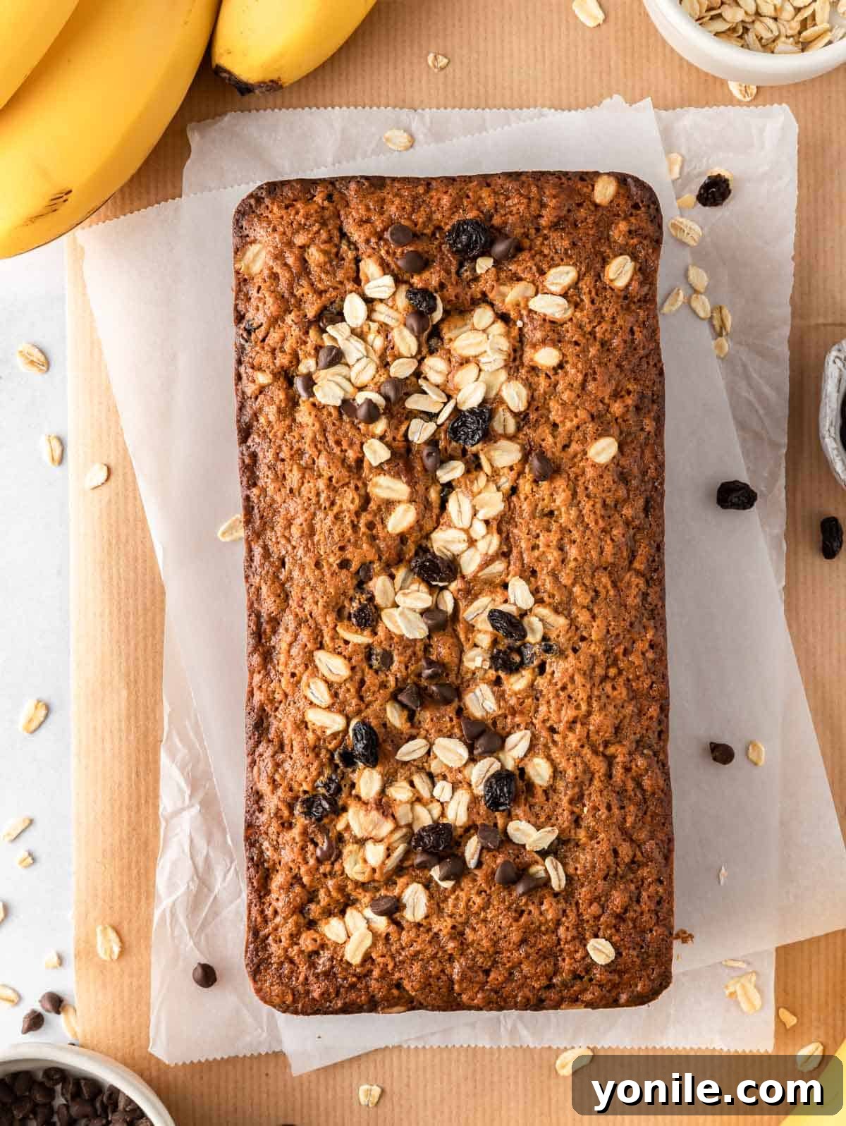 Wholesome Oat Banana Loaf 2 A beautifully baked loaf of healthy oatmeal banana bread on parchment paper, ready to be sliced.