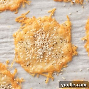 Crispy Parmesan Bites 8 Parmesan cheese chips topped with seasoning on a tray.