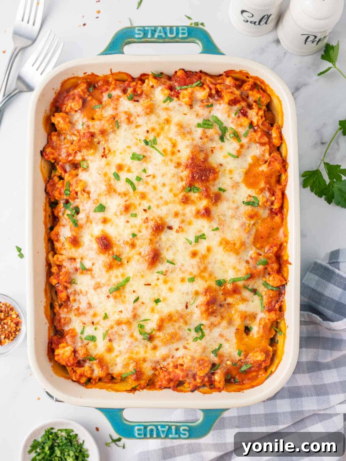 Baked alfredo pasta topped with cheese in a casserole dish, ready to be served.
