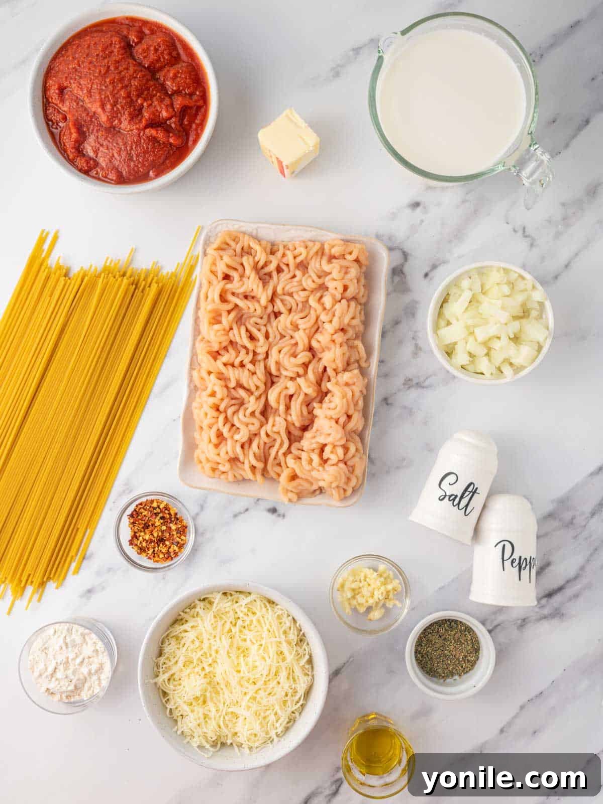 Ingredients needed for spaghetti alfredo laid out on a kitchen counter.