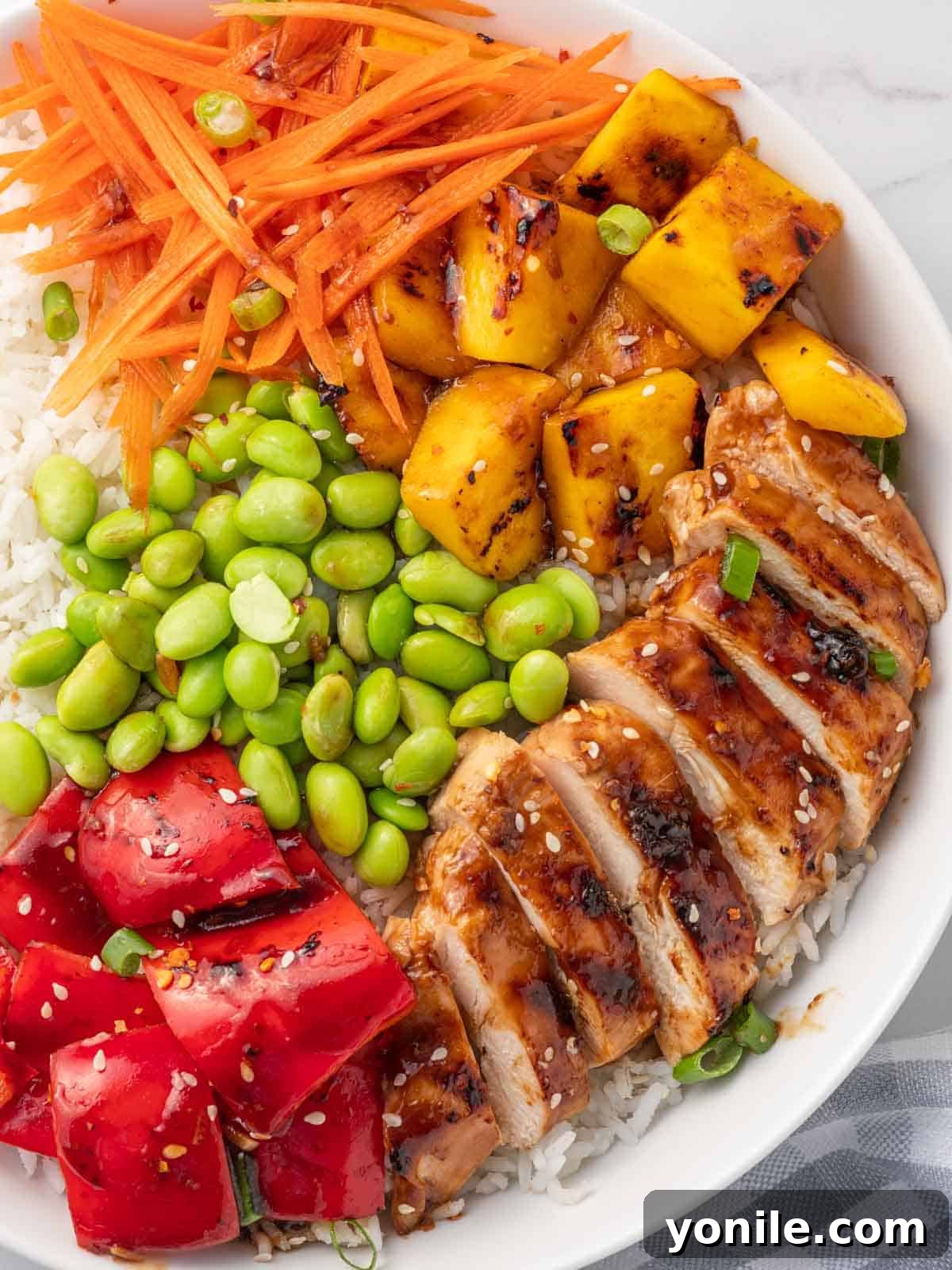 Another close-up of a perfectly arranged chicken teriyaki rice bowl, highlighting the colorful ingredients and succulent chicken.