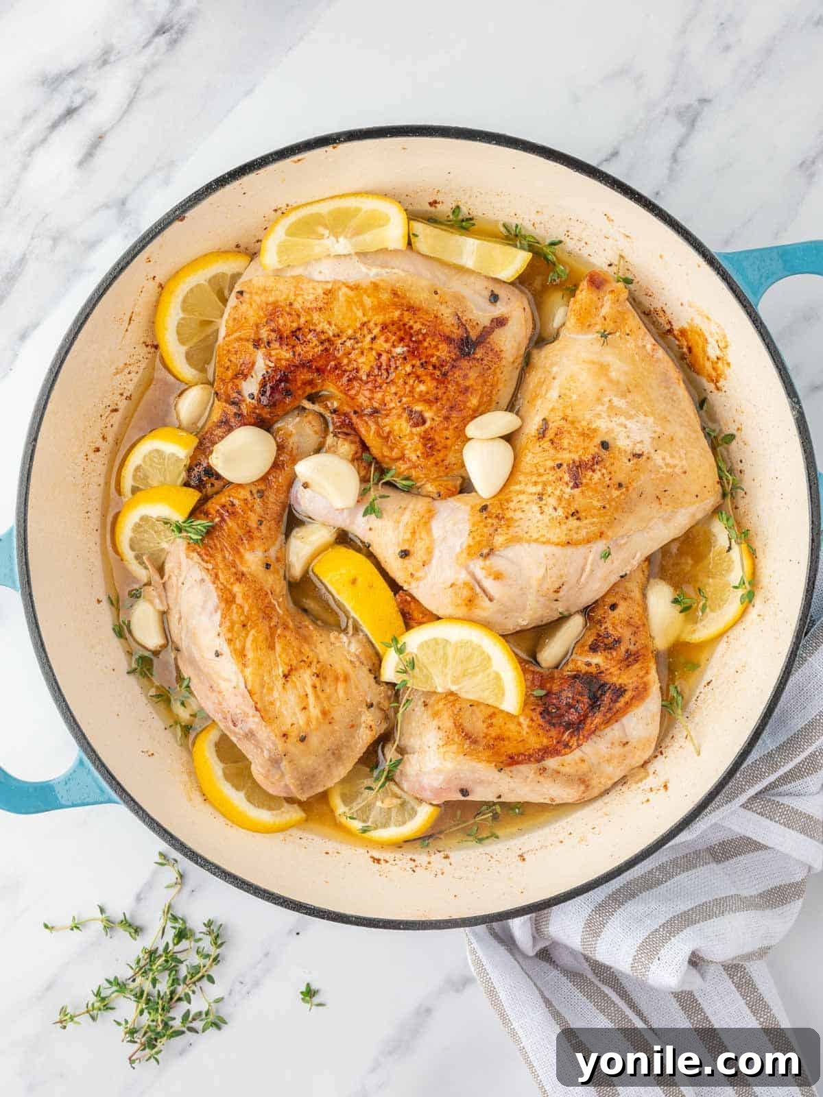 braised chicken legs in a skillet with aromatics.