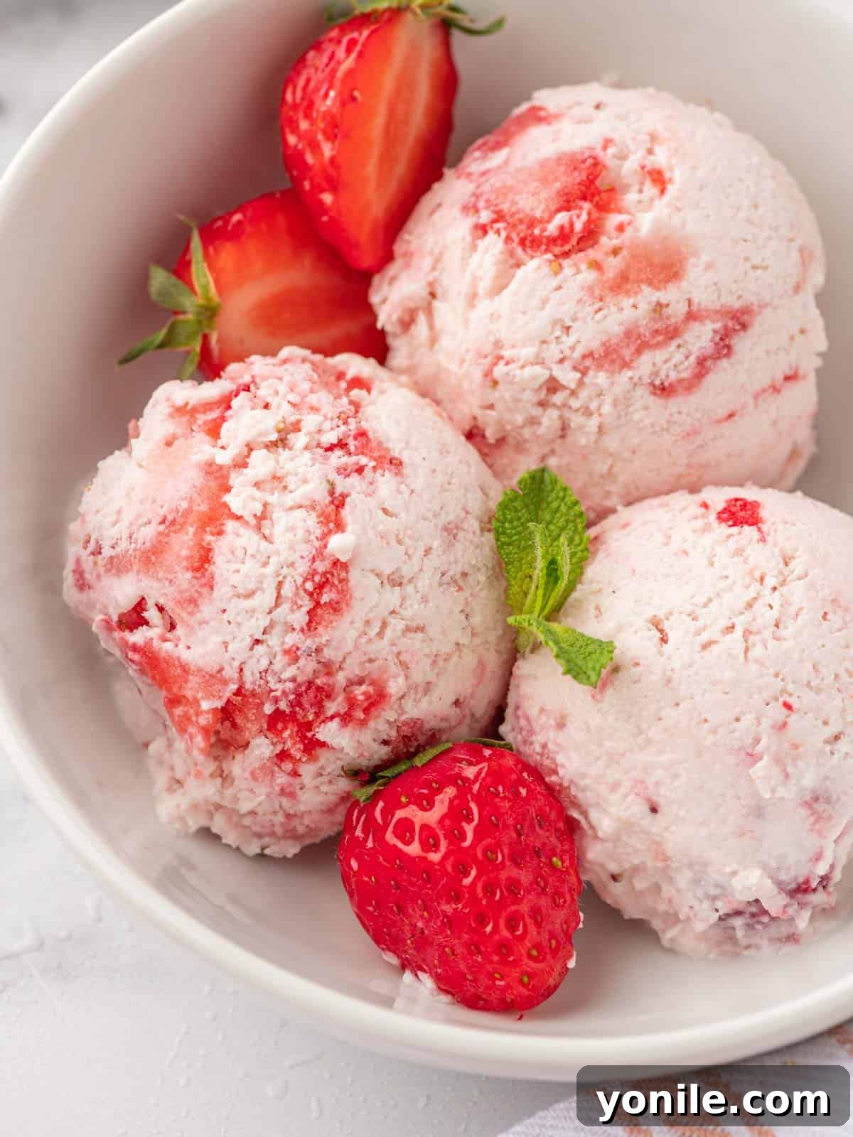 Scoops of strawberry ice cream in a bowl.