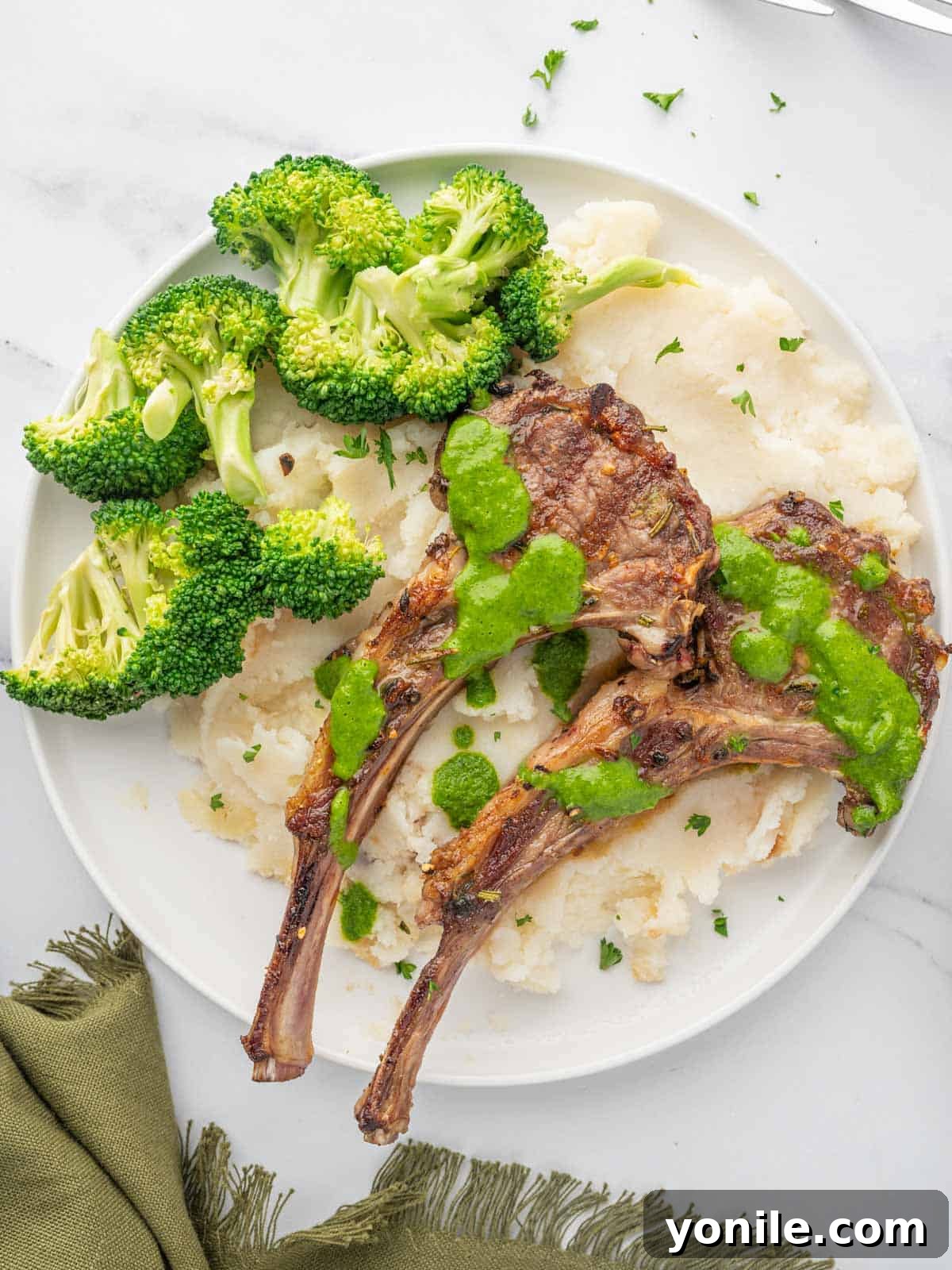 A complete meal of Mediterranean lamb chops served with creamy mashed potatoes and vibrant green broccoli.