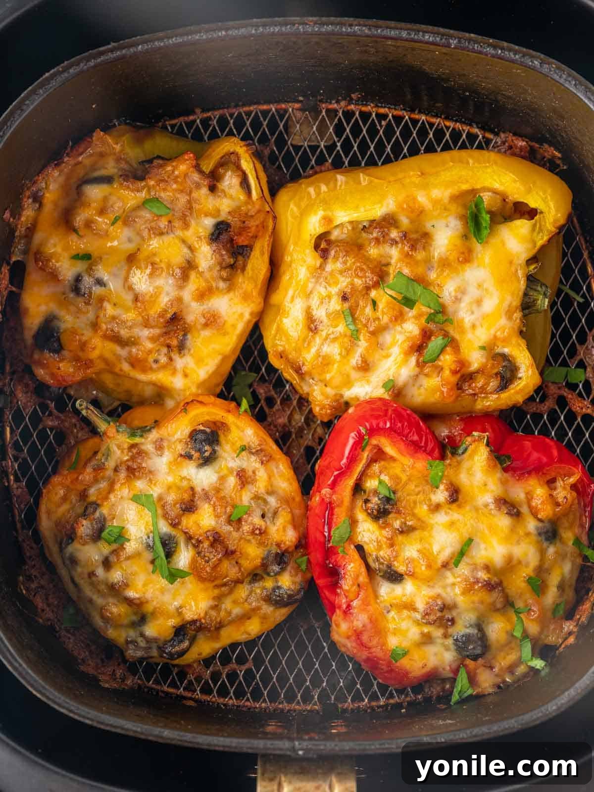 Cheese melted over stuffed peppers in air fryer.