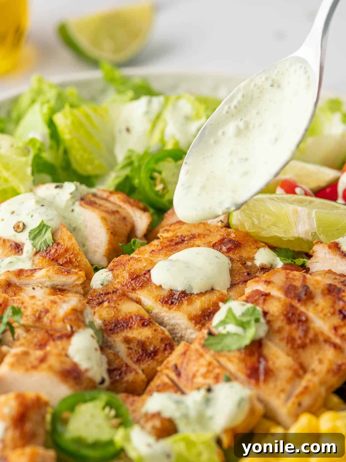 Fiesta Chicken Salad 7 A spoon drizzles cilantro lime dressing over the salad.