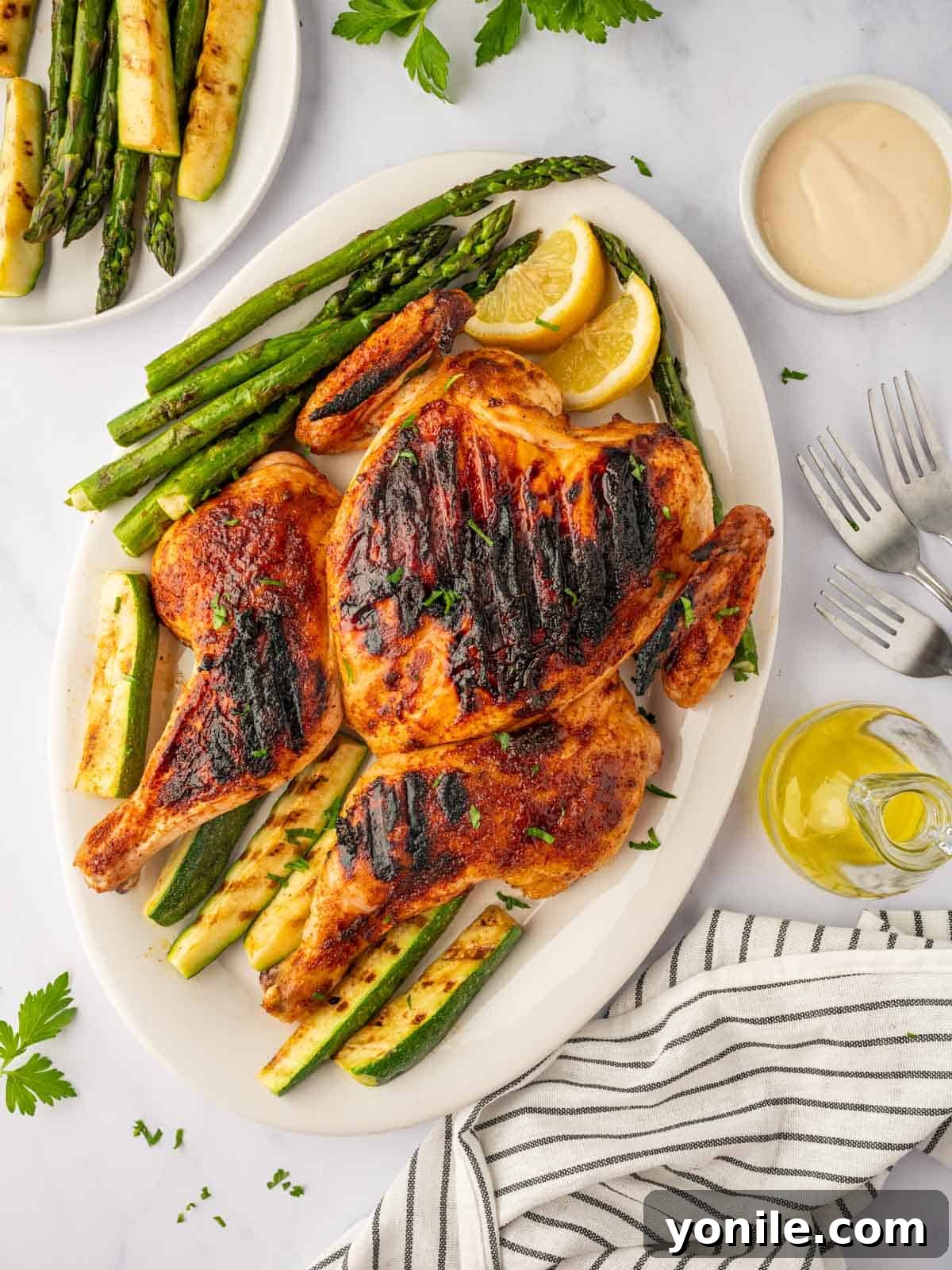 Roast chicken on a grill with roasted veggies.