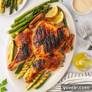 Roast chicken on a grill with roasted veggies.
