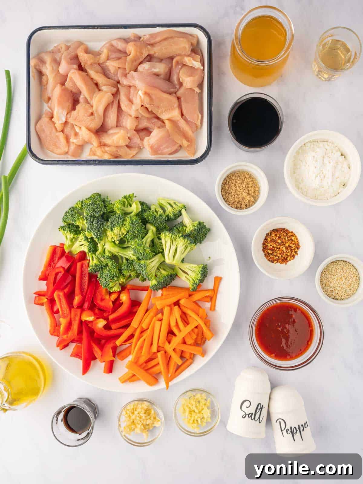 Fiery Hunan Chicken 3 Ingredients needed to make Chinese Hunan chicken, including fresh chicken, colorful vegetables, and various sauces.