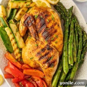 A grilled half chicken on a platter.
