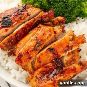 Oven baked BBQ chicken thighs with fluffy rice and steamed broccoli, a complete and satisfying meal.