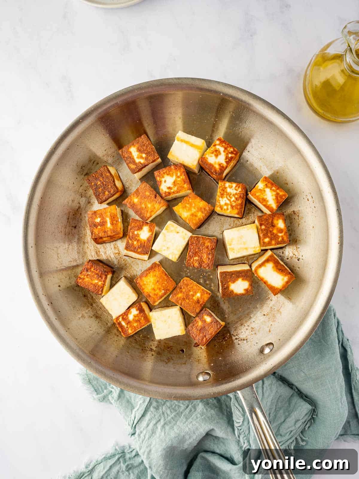 Royal Paneer Pasanda 5 Paneer cubes frying in a pan until golden brown on all sides.