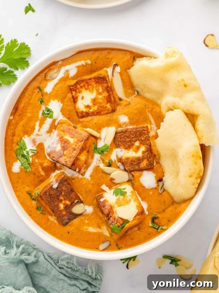 Royal Paneer Pasanda 10 A bowl of Paneer Pasanda served with fluffy naan bread.