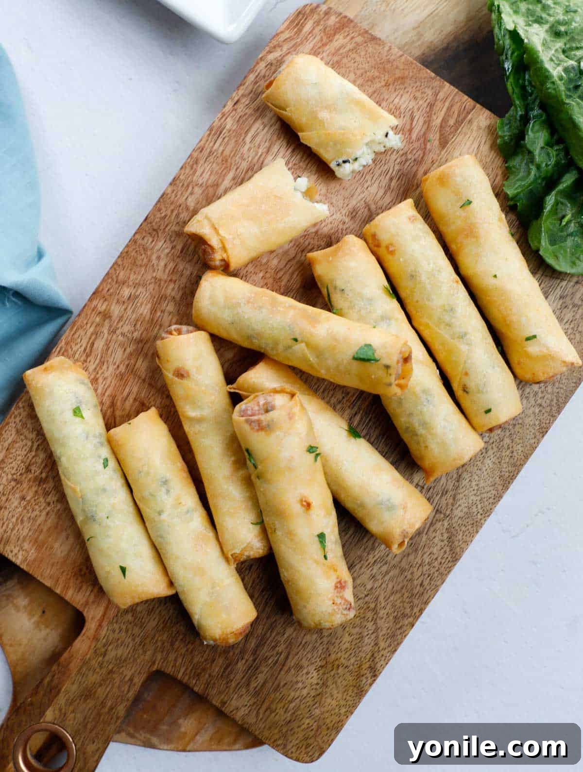 Crispy Cheese Rolls 2 Fried Lebanese Cheese Rolls, perfectly golden and crispy, arranged elegantly on a rustic wooden board, ready to be served.