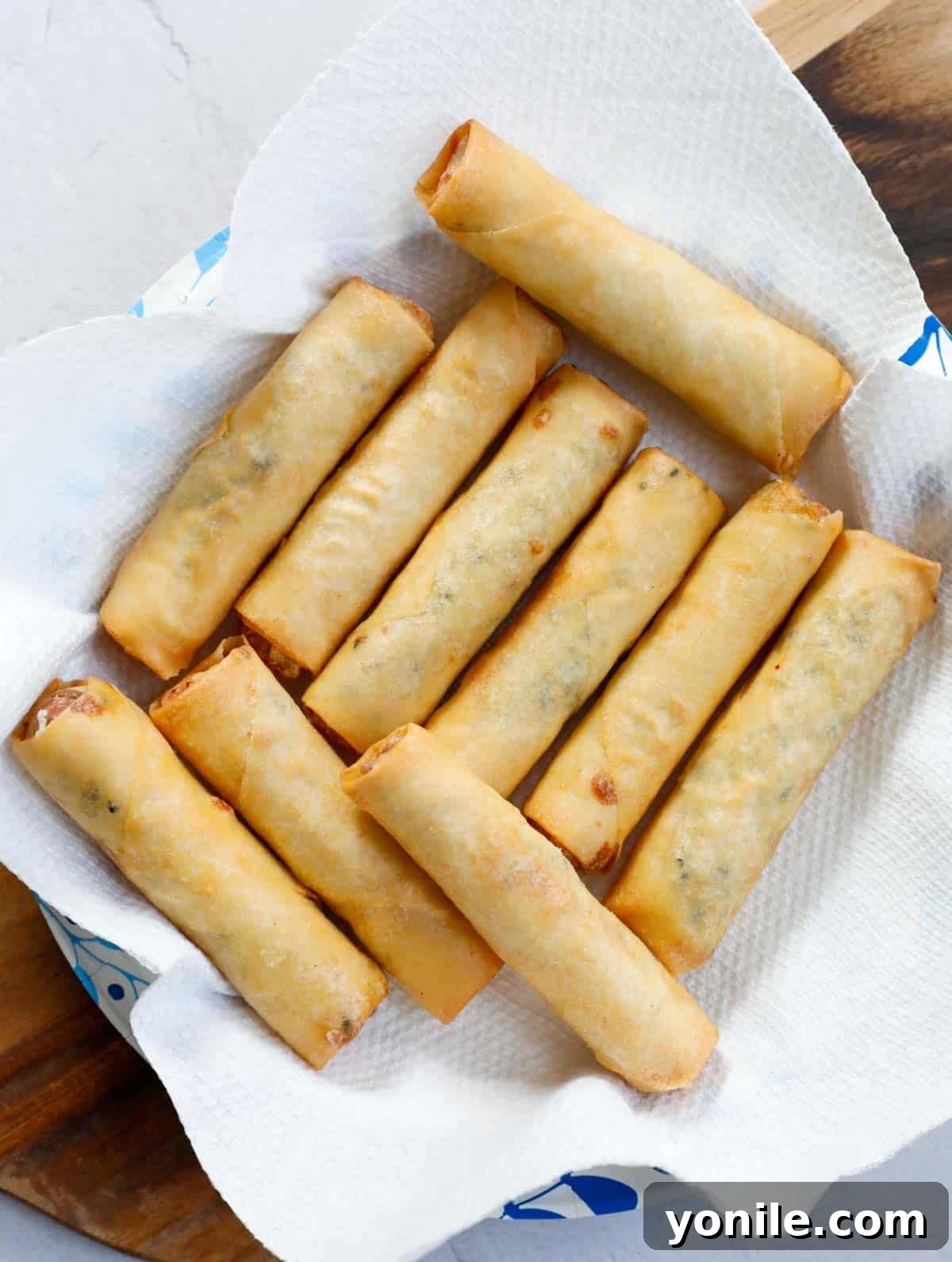 Crispy Cheese Rolls 7 Freshly fried Lebanese Cheese Rolls, still glistening from the oil, resting on a bed of paper towel to absorb excess oil, ready to be served warm and crispy.