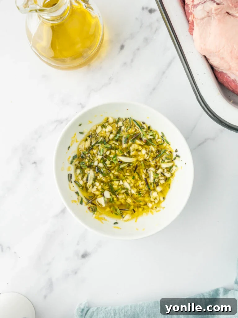 Close-up view of a bowl containing a freshly prepared garlic and rosemary marinade, showcasing its vibrant texture and rich colors.