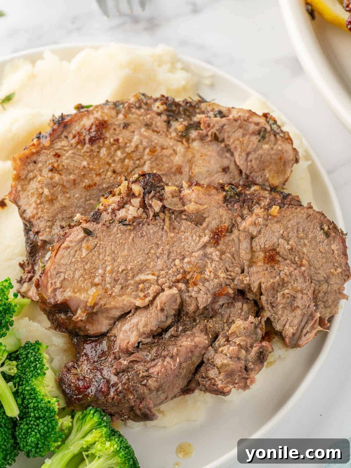 Artfully arranged slices of perfectly roasted lamb on a serving plate, highlighting its tender texture and inviting presentation.