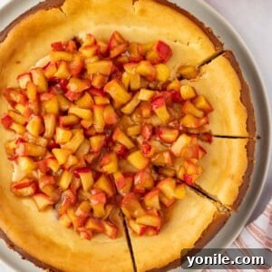 Apple cheesecake cut into slices, showcasing the creamy filling and apple topping.