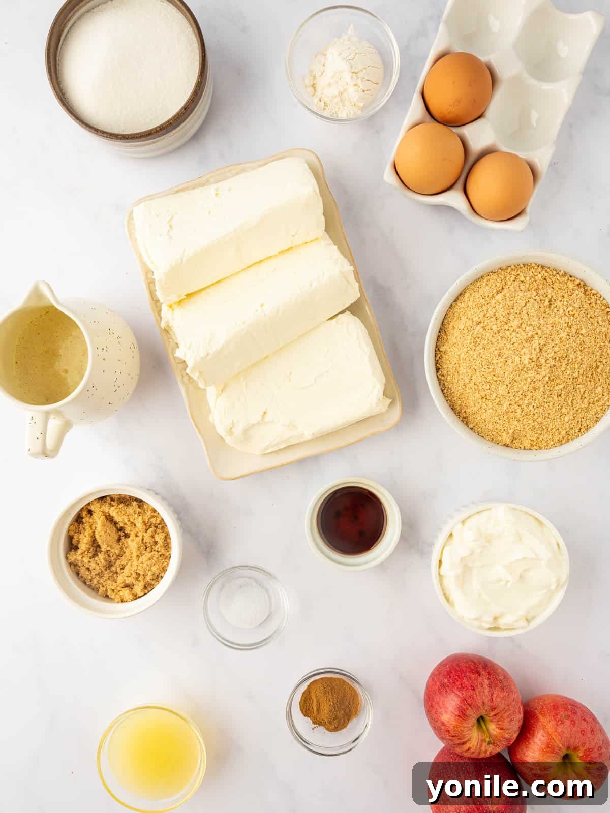 All the fresh and pantry ingredients laid out, ready for baking the delicious cinnamon apple cheesecake.