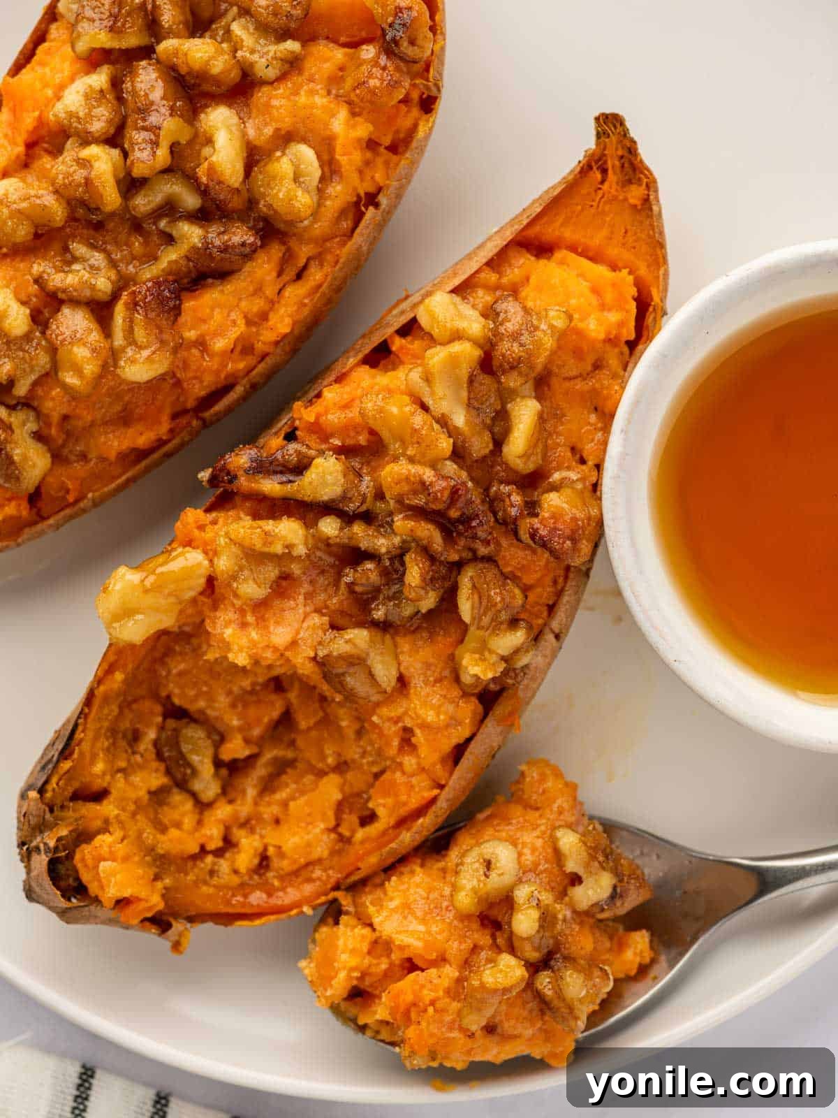 A spoon scoops a bite of sweet potatoes.