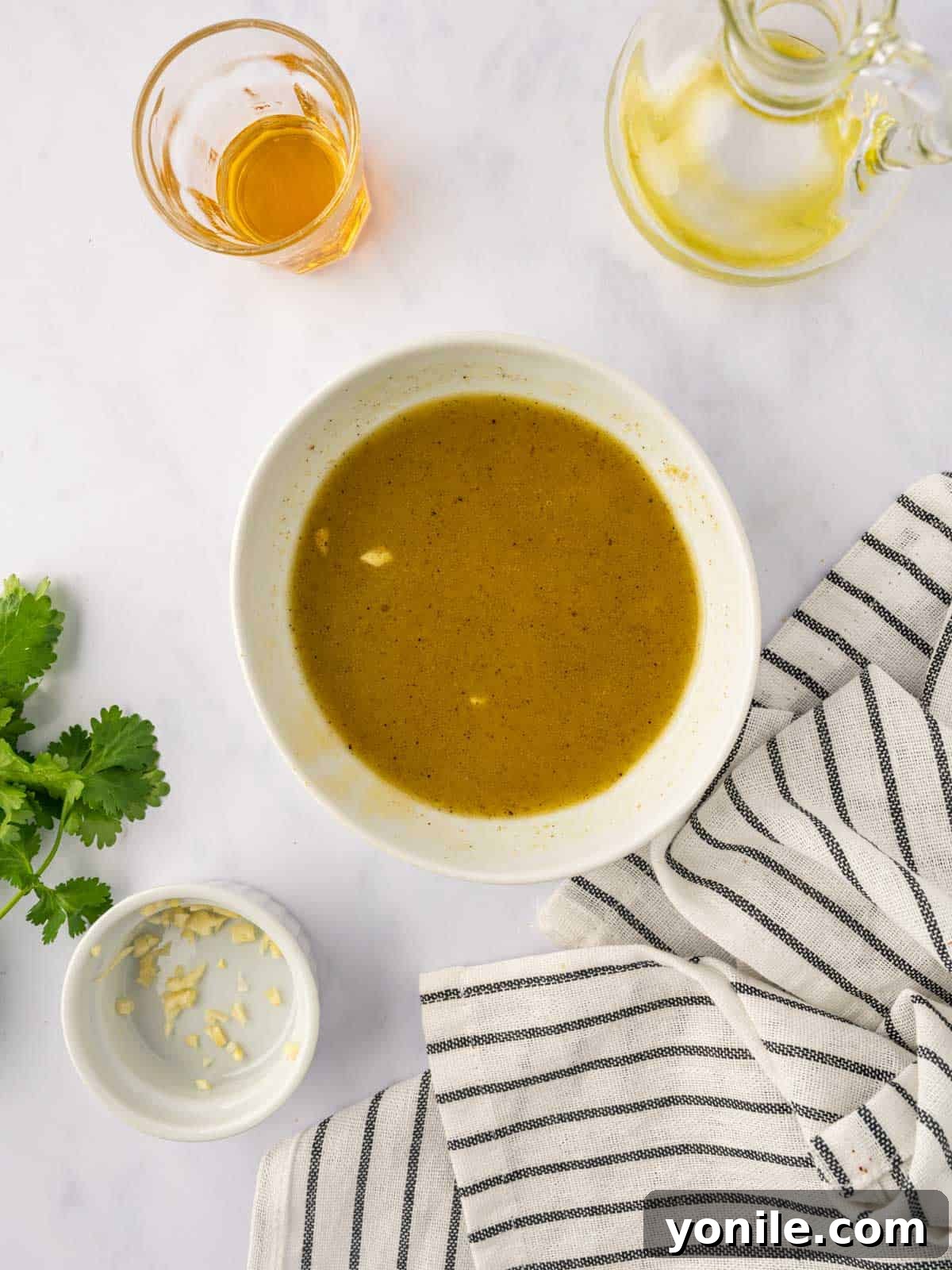 A small bowl holding a freshly prepared salad dressing, ready to be drizzled over the salad.