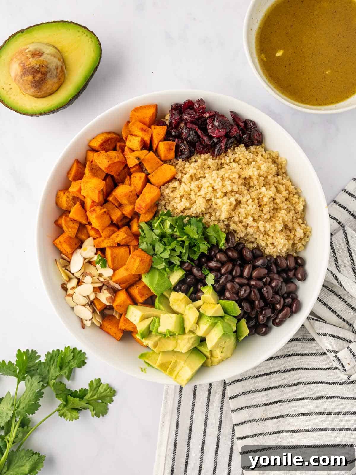 All the cooked and prepared ingredients for the quinoa salad piled invitingly in a large mixing bowl.
