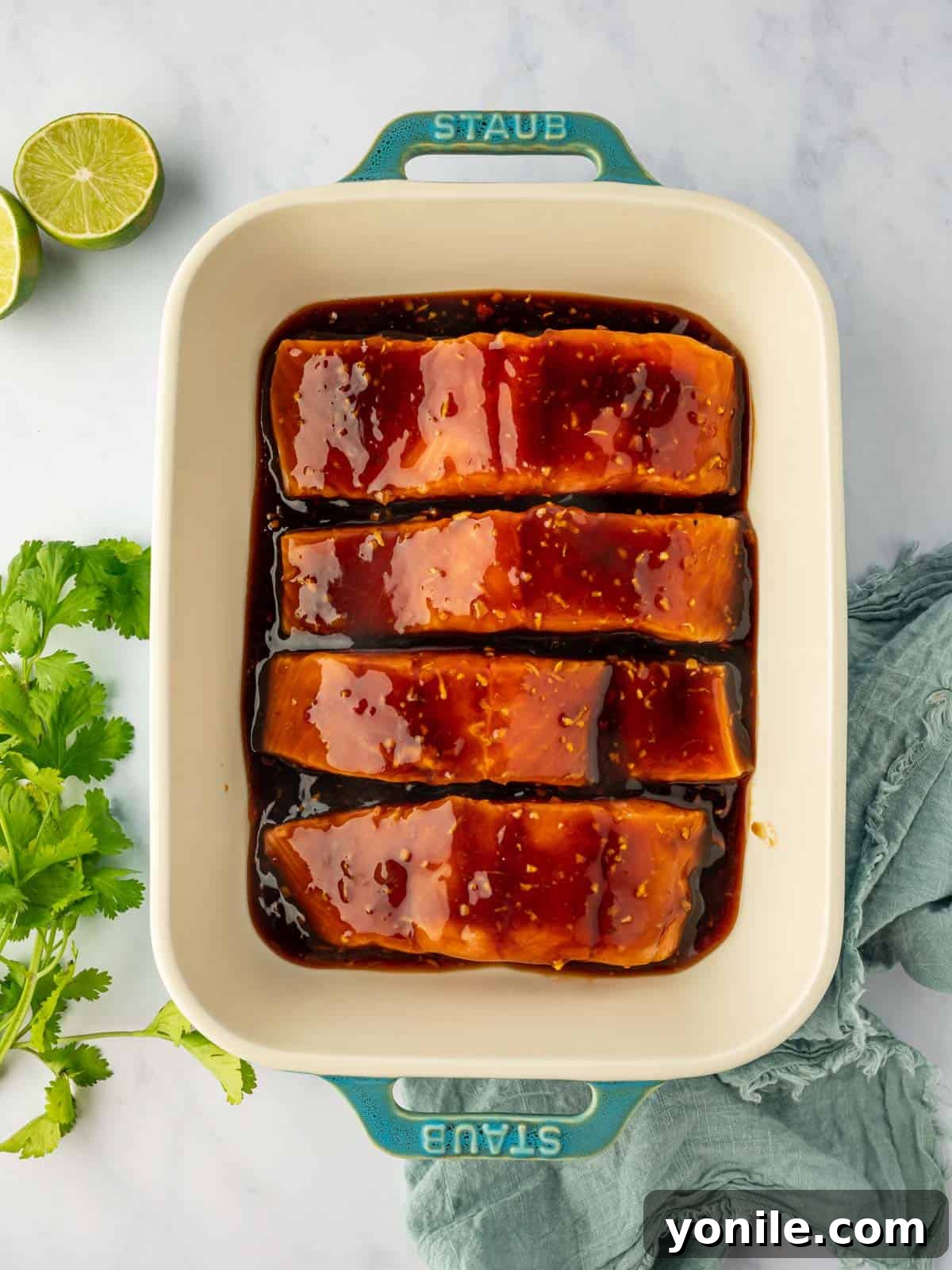 Thai Chili-Lime Baked Salmon 6 Salmon fillets soaking in a luscious, colorful Thai marinade within a baking dish, perfectly coated and ready for the oven.
