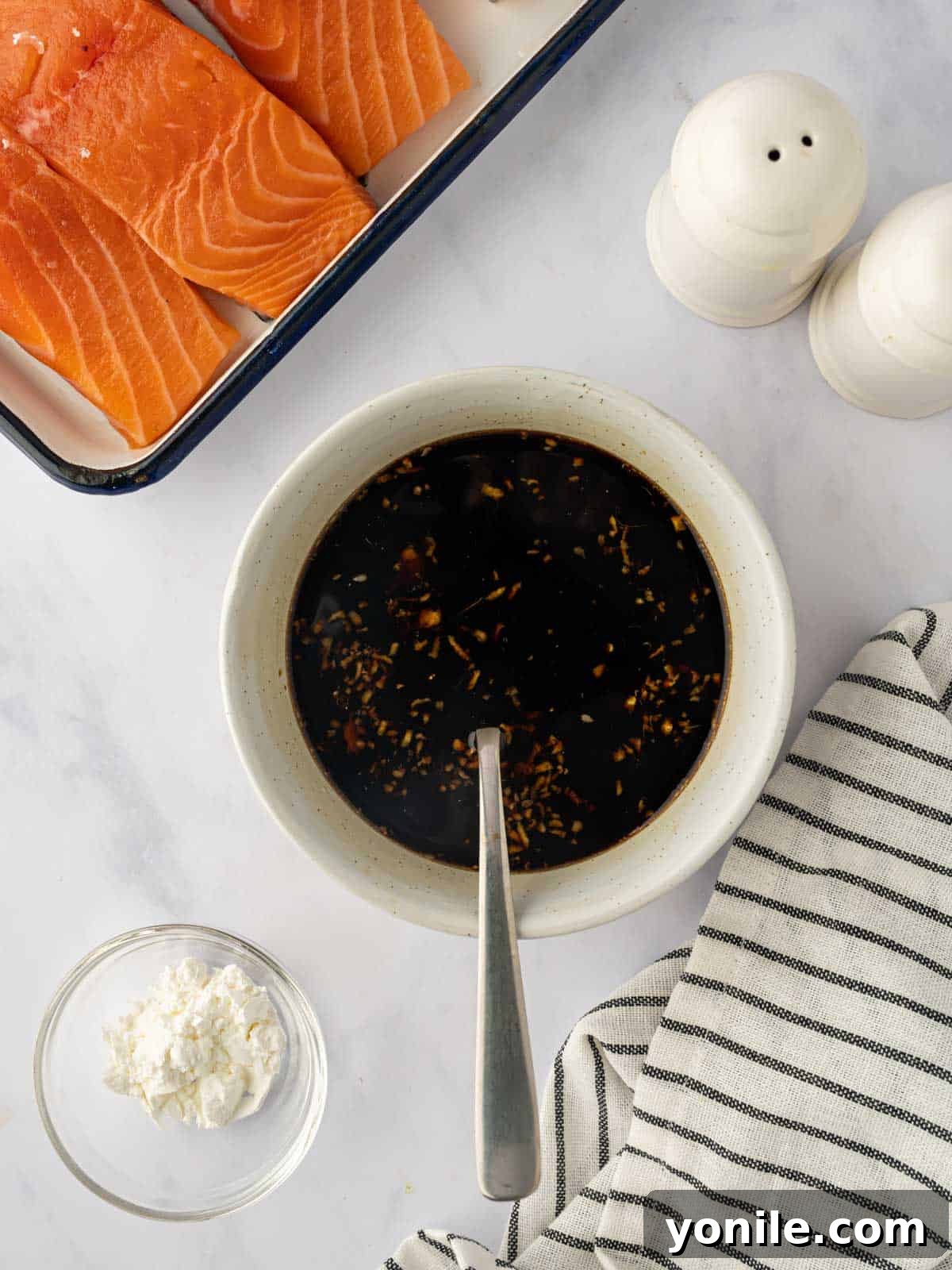 Various ingredients for the teriyaki marinade, including soy sauce, brown sugar, ginger, and garlic, combined in a bowl.