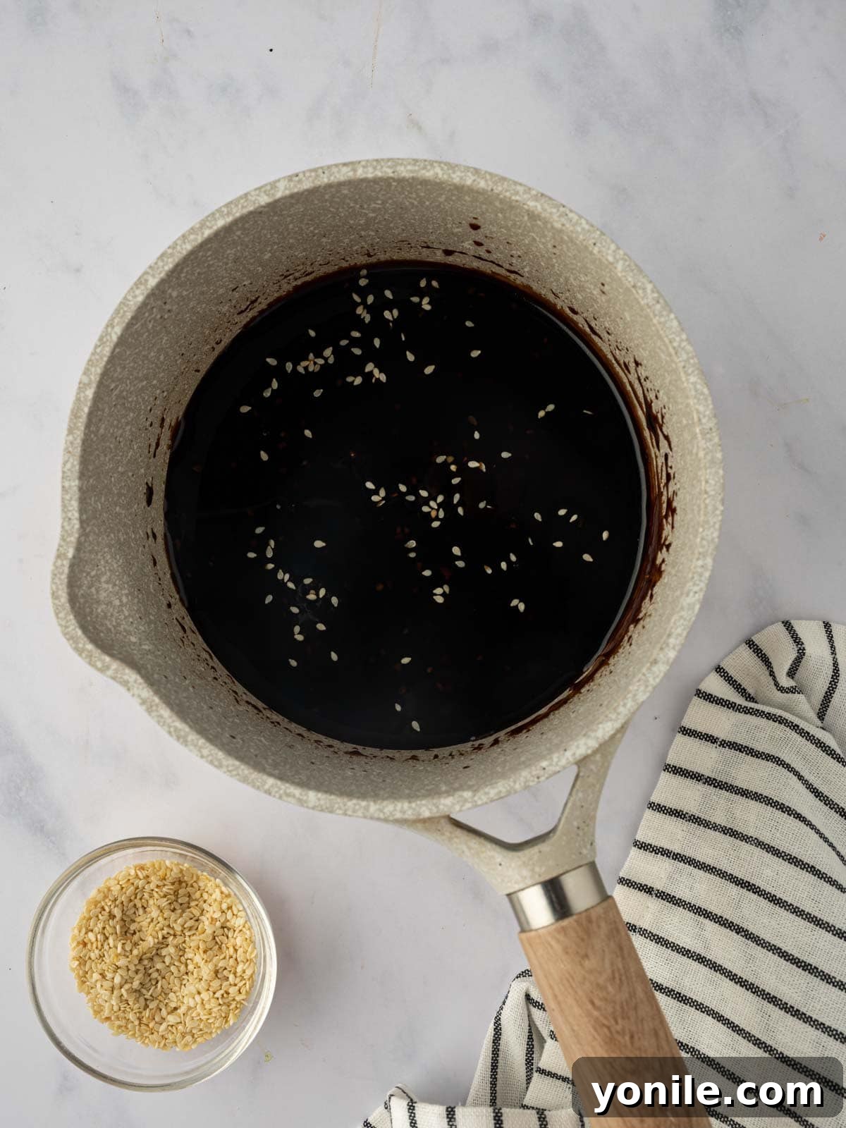 The simmering teriyaki marinade, reduced and thickened in a saucepan, ready for glazing.